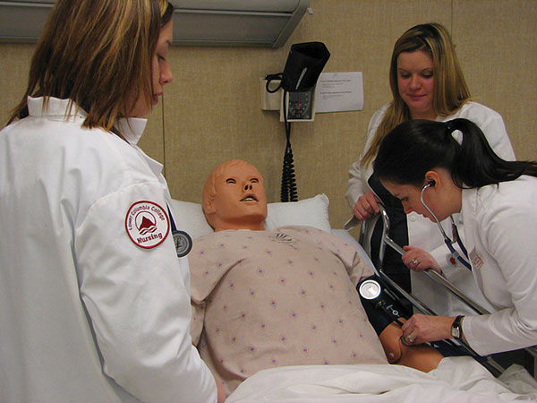 Nursing students test their knowledge on a dummy patient at Lower Columbia College. Photo by Wayne Hsieh.